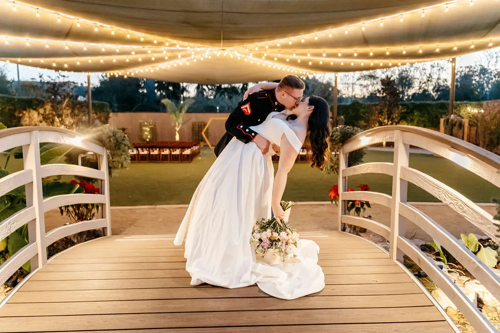Couple dancing under string lights at a wedding